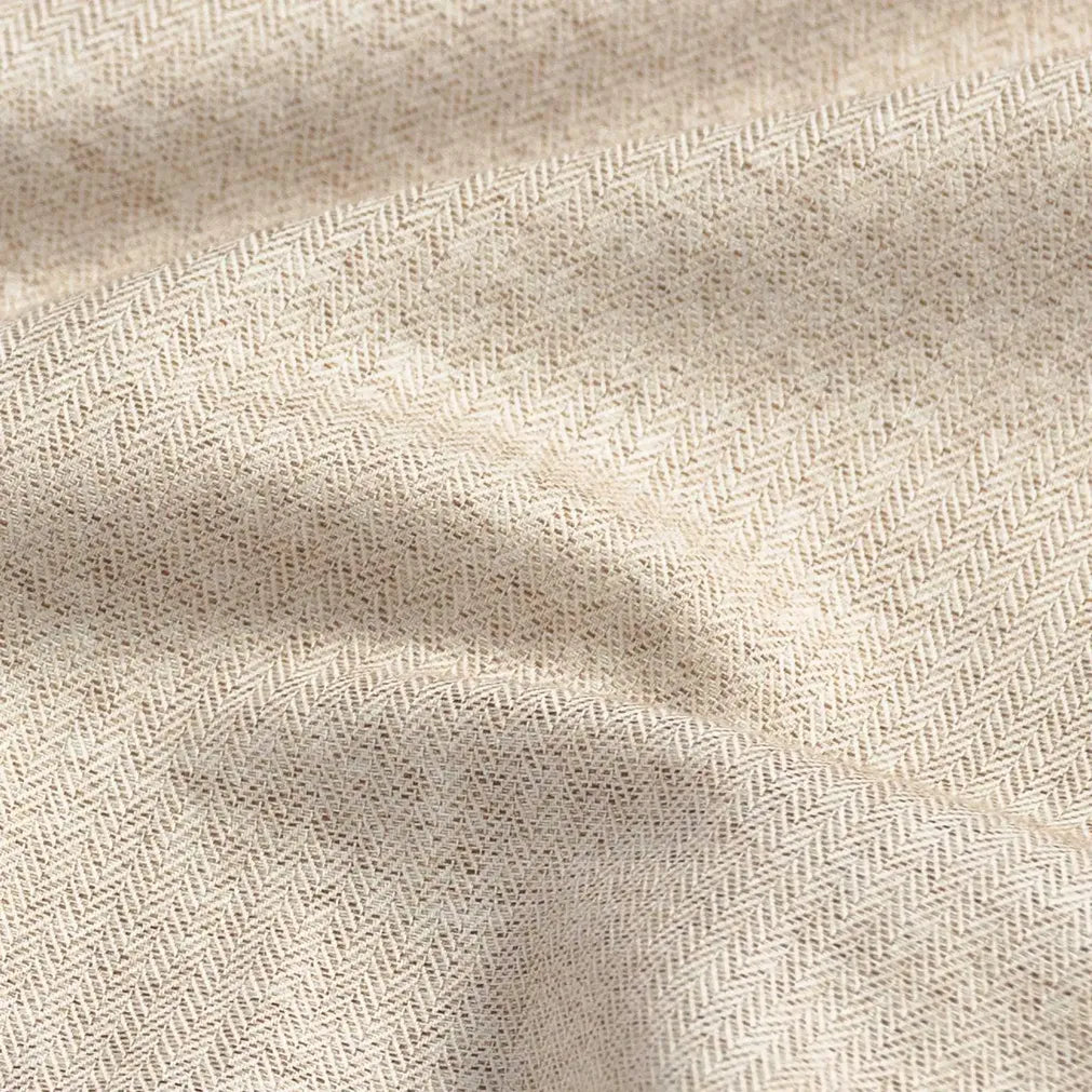 Close-up of an oatmeal fabric with a subtle herringbone pattern