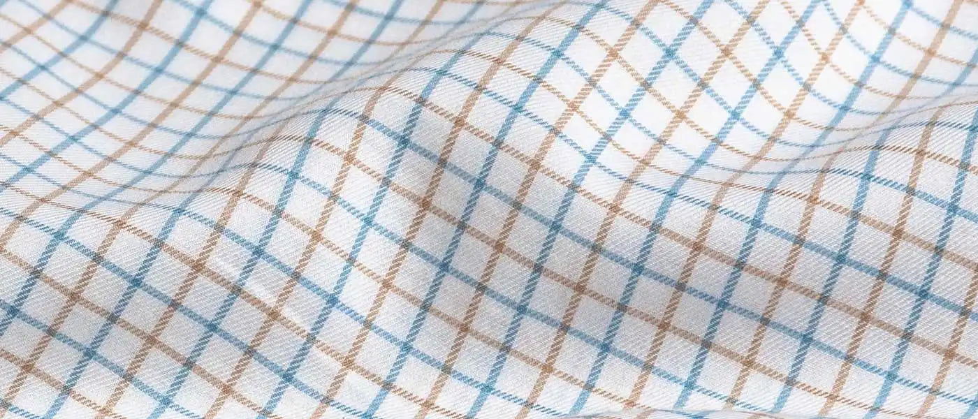 Close-up of checkered fabric with blue and brown lines on a white background