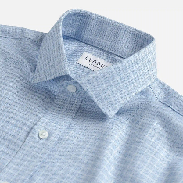 Close-up of a light blue and white checkered button-down shirt collar with a visible LEDBUDD brand label.