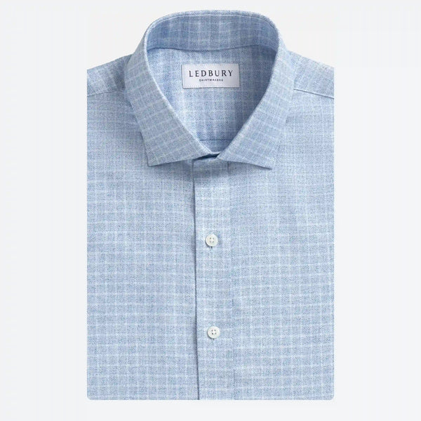 A folded light blue and white checkered dress shirt by Ledbury, featuring a classic collar, white buttons, and a clean white background.
