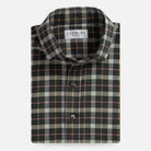 A folded long-sleeve plaid shirt by Ledbury, featuring a dark gray and black base with beige, yellow, and pink intersecting stripes, shown on a light gray background.