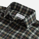 Close-up of a plaid button-down shirt collar with a visible LEDBURY label. The fabric has a dark charcoal base with intersecting gray, white, yellow, and pink plaid lines.