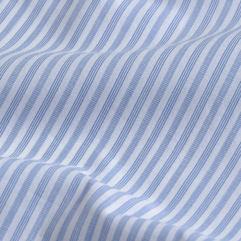 A close-up of a blue and white striped fabric with a fine textured weave and soft folds.