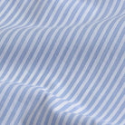 A close-up of a blue and white striped fabric with a fine textured weave and soft folds.