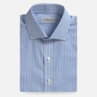 A folded men's dress shirt by Ledbury, featuring light blue and white vertical stripes, a classic collar, and white buttons, set against a clean off-white background.