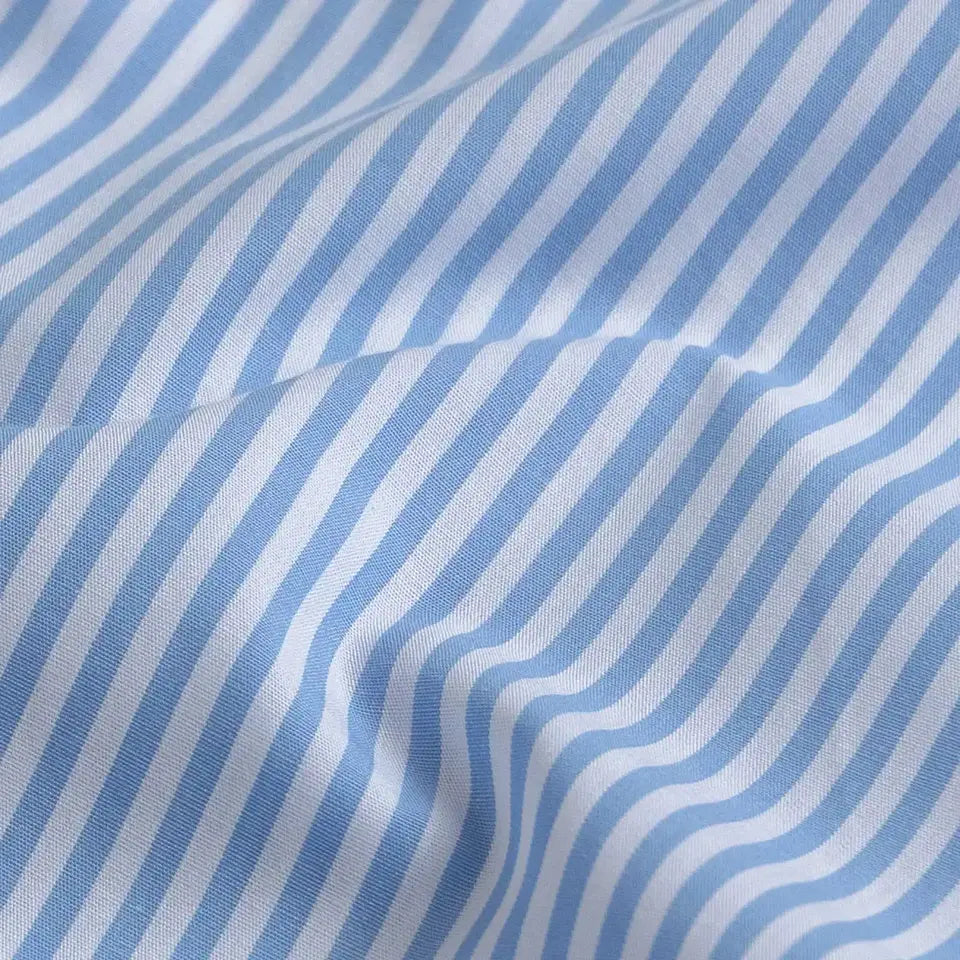 A close-up of light blue and white striped fabric with soft folds showing the woven texture.