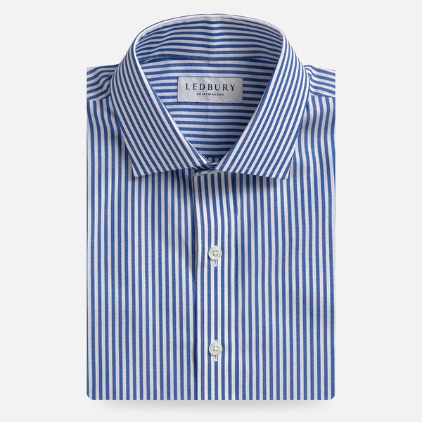 A folded men's dress shirt by Ledbury, featuring a blue and white vertical stripe pattern, a classic collar, and white buttons, presented on a clean light gray background.