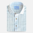 A folded light beige and white checkered dress shirt with brown buttons, featuring a visible LEDBURY brand label on the collar, set against a light gray background.