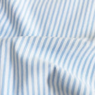 A close-up of light blue and white vertically striped fabric with a soft draped fold.