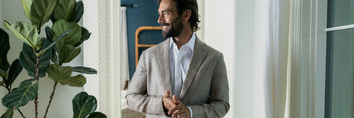 Model wearing a white Ledbury dress shirt and a tan suit