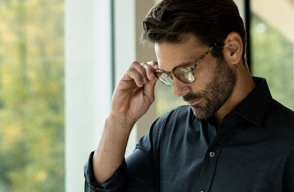 Man wearing a pair of inexpensive reading glasses