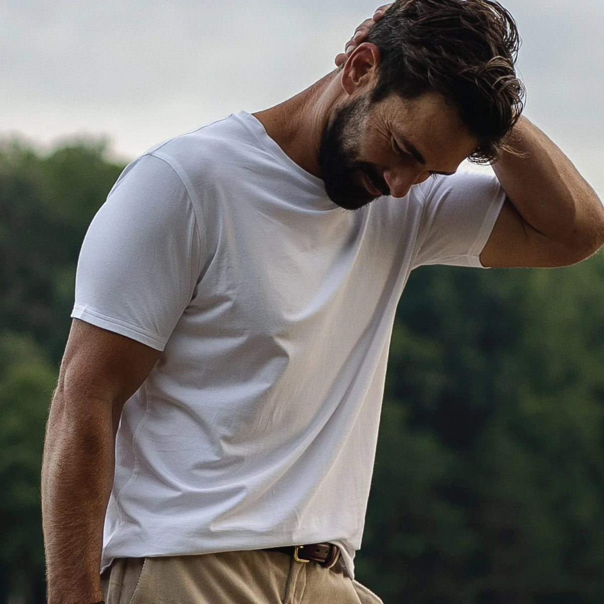 Model wearing the Ledbury white crew neck undershirt, standing in an outdoor setting. 