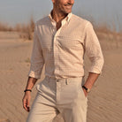 Model wearing a breathable cotton linen button down shirt in pale pink and cream 