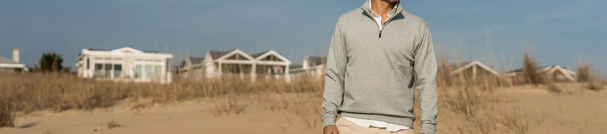 Man standing on the beach wearing a Ledbury quarter zip pullover