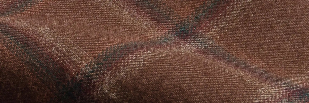 A close-up of a brown woven fabric with a subtle plaid pattern in dark brown and black.