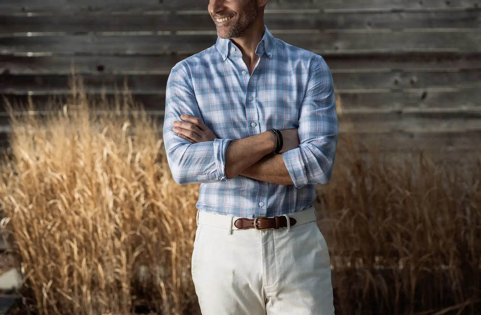 Model wearing a blue, white and pink check button down shirt by Ledbury