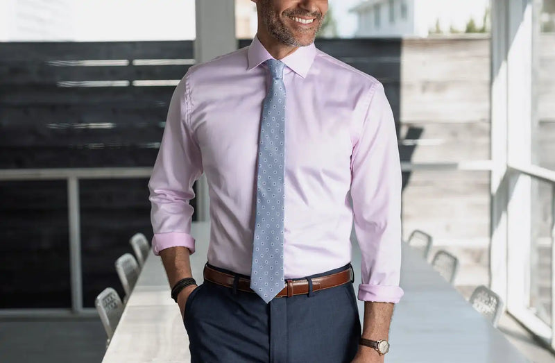 Model wearing a pink Ledbury non iron dress shirt with a light blue tie