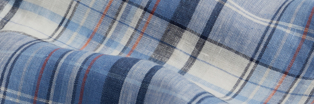 Closeup of the fabric of a mens navy blue, white and red linen blend button down shirt