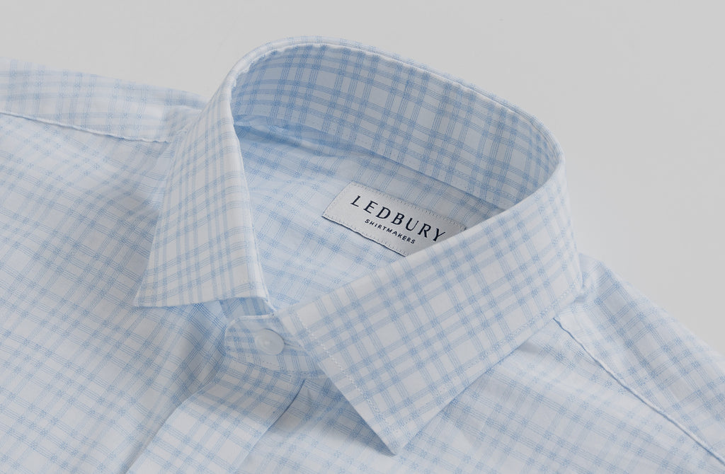 A collar close up of the light blue and white ellis plaid shirt.