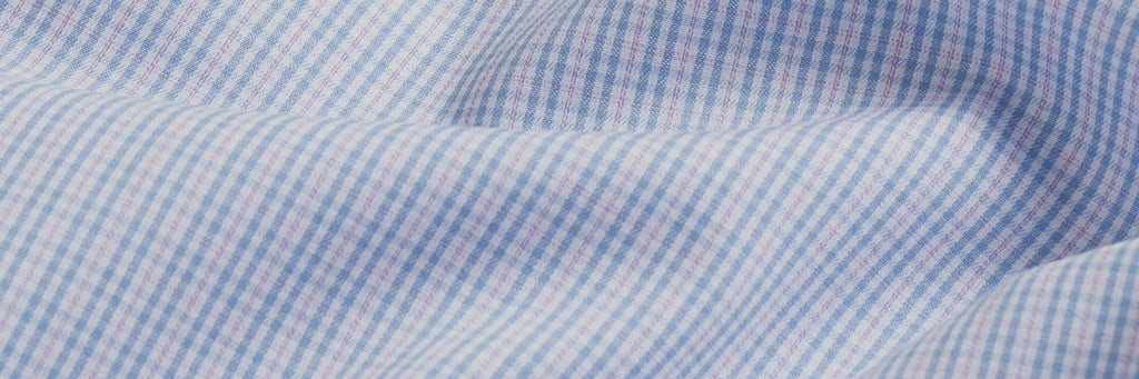 Closeup of the fabric of a men's small scale blue and pink tattersall dress shirt