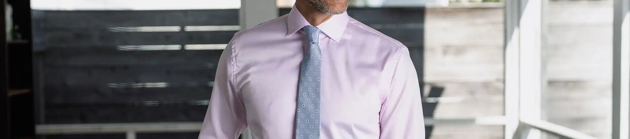 Man wearing a pink dress shirt with a light blue Ledbury tie