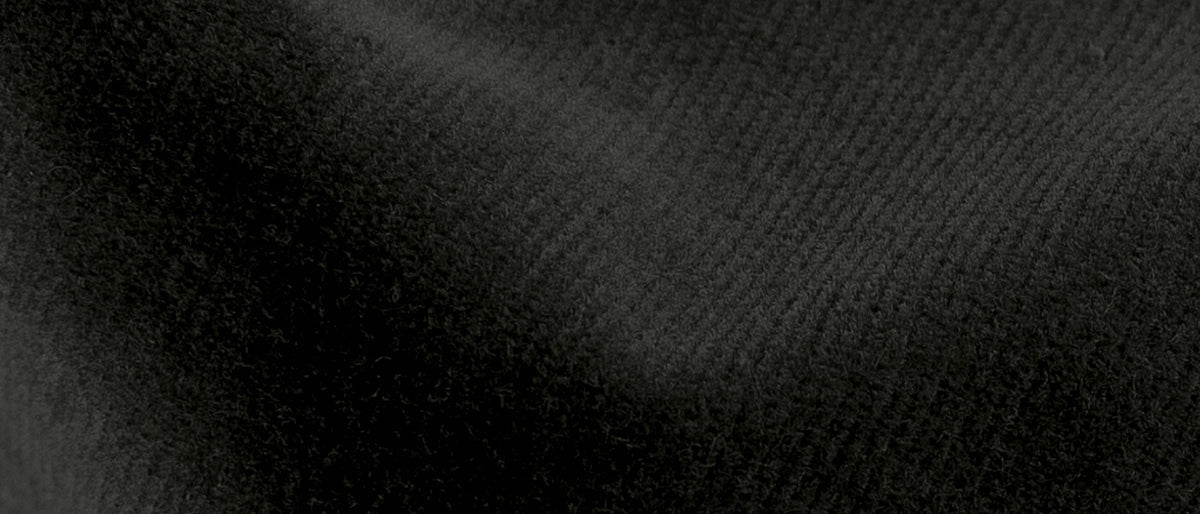 A close-up of a dark forest green corduroy texture, showing the fine vertical ribbing and soft folds.
